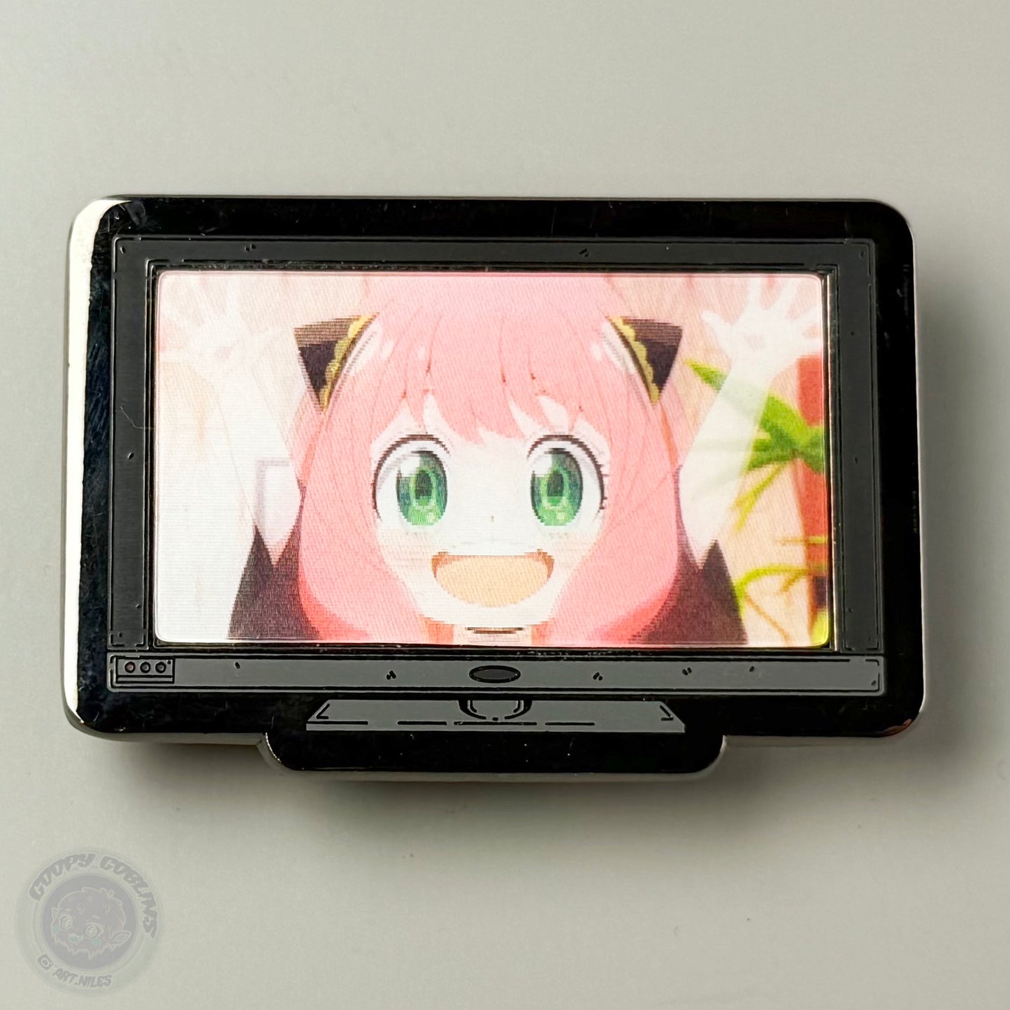 Small screen displaying an animated character with pink hair and green eyes on a light gray background.