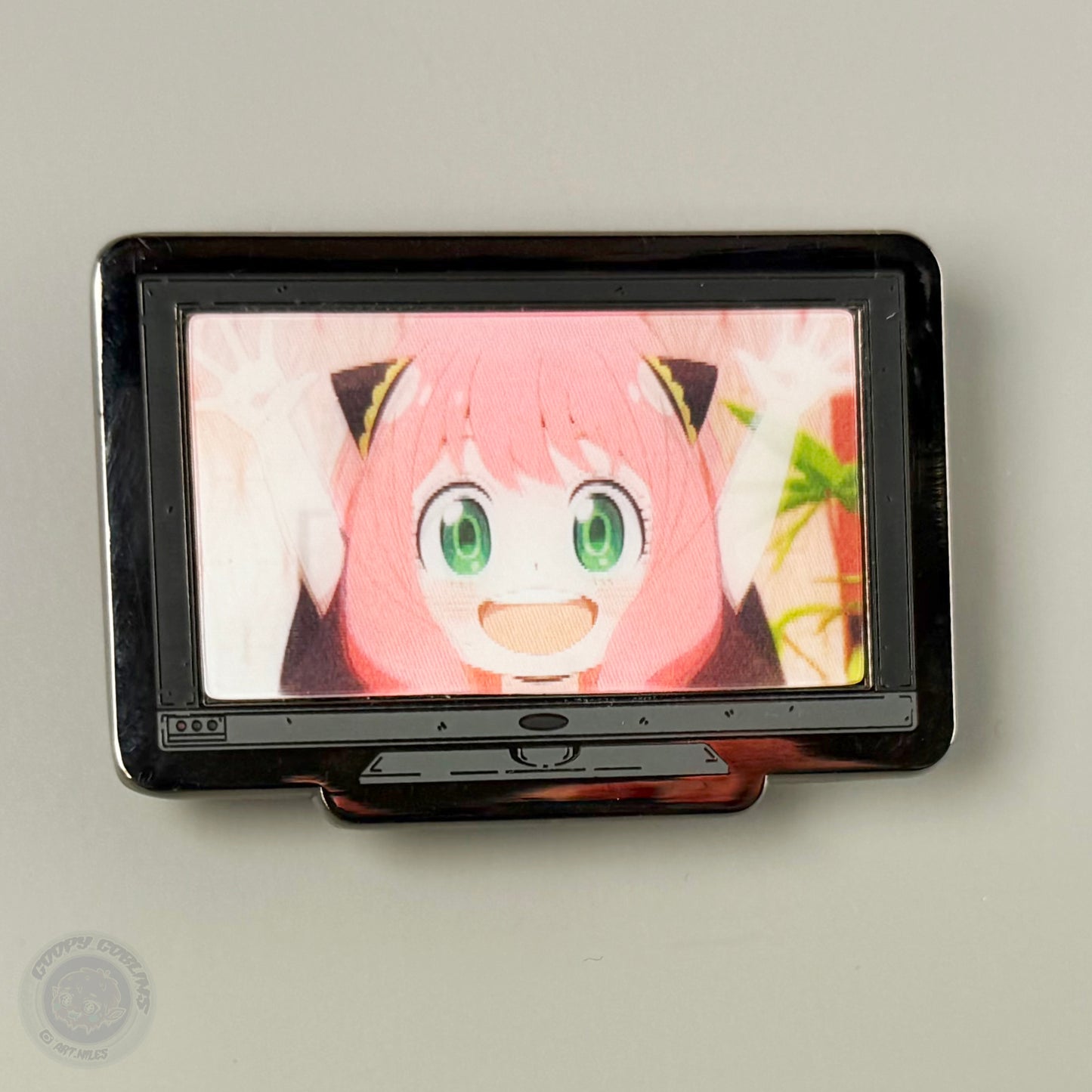 Small screen displaying an animated character with pink hair and green eyes on a gray background