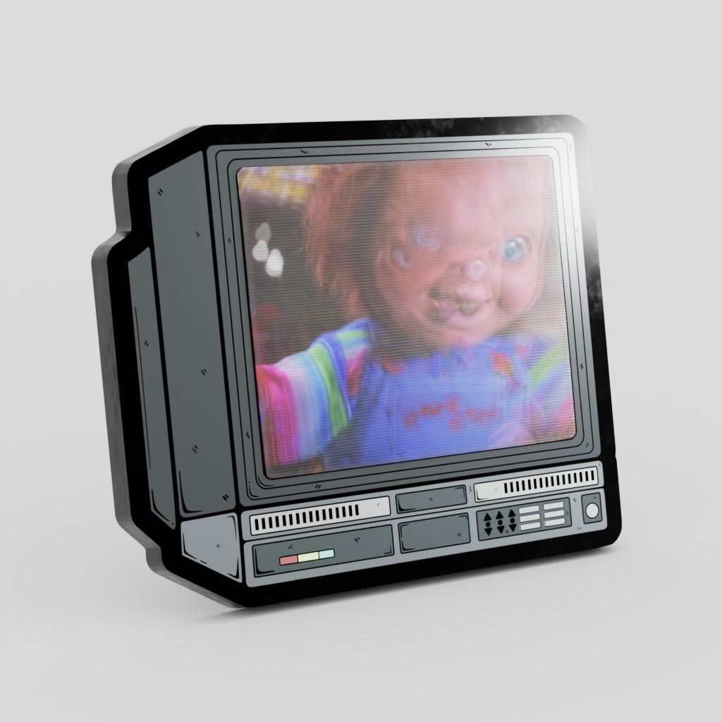 Vintage-style television set with a doll on the screen against a light gray 
background Chucky Lenticular Enamel Pin