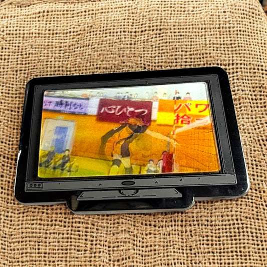 Small screen displaying a colorful graphic on a textured beige surface
