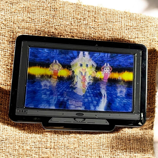 Small screen displaying a colorful pixelated image on a textured fabric background