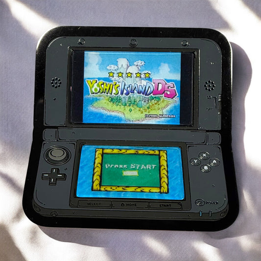 Black handheld gaming console displaying 'Yoshi's Island DS' on a light background
