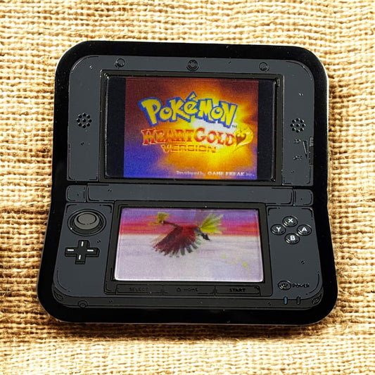 Nintendo DS with 'Pokémon Heart Gold' game displayed on a textured surface