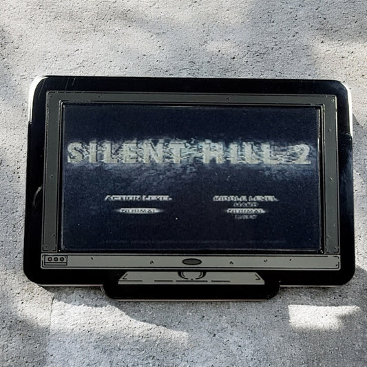 Vintage gaming console with 'Silent Hill 2' title screen on a concrete surface