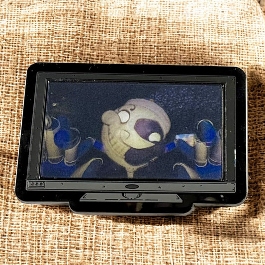 Small screen displaying an animated character on a textured fabric background