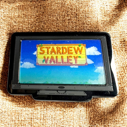 Small screen displaying 'Stardew Valley' on a textured brown background