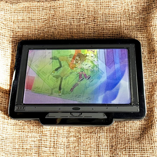 Small screen displaying colorful abstract art on a textured fabric background