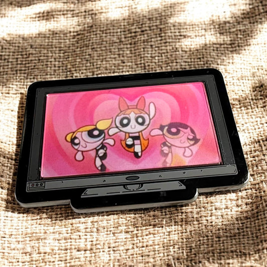 Small screen displaying cartoon characters on a textured fabric background